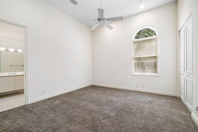 unfurnished bedroom featuring light colored carpet, ensuite bath, visible vents, and baseboards