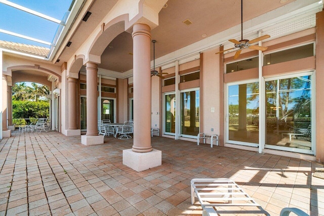 view of patio featuring a lanai, outdoor dining space, and a ceiling fan