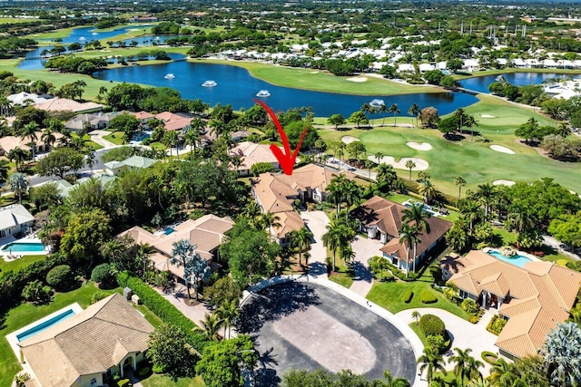 drone / aerial view with golf course view, a water view, and a residential view