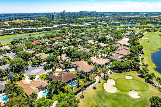 drone / aerial view with view of golf course, a residential view, and a water view