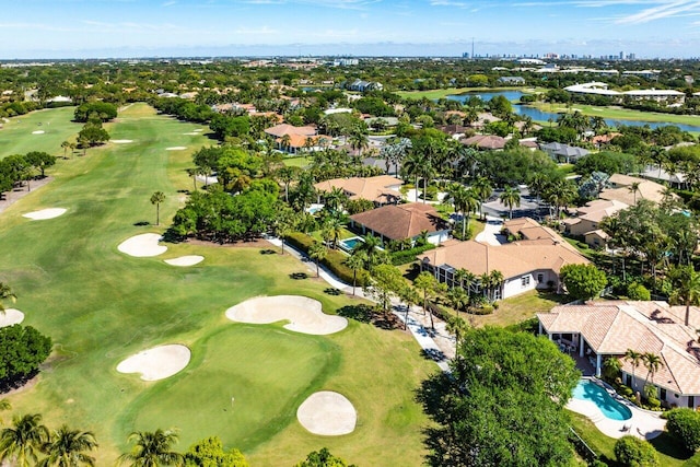 drone / aerial view featuring view of golf course, a residential view, and a water view