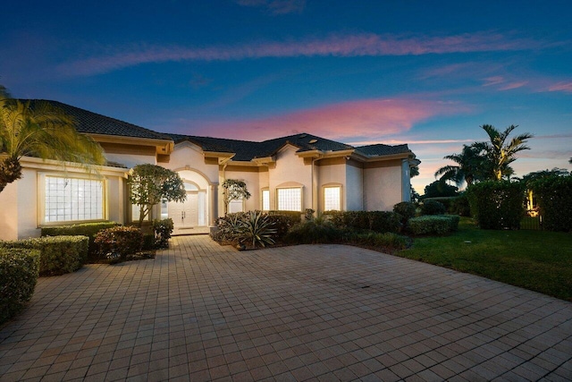 mediterranean / spanish-style house with stucco siding and curved driveway