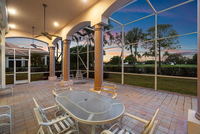 view of patio / terrace with outdoor dining area, a lanai, and ceiling fan