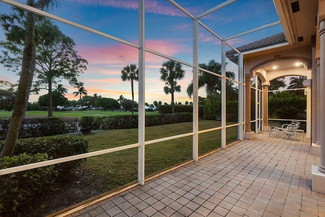 unfurnished sunroom with arched walkways