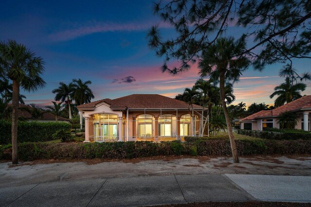 mediterranean / spanish house featuring a tiled roof and stucco siding