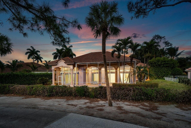 view of front facade with a tile roof and stucco siding