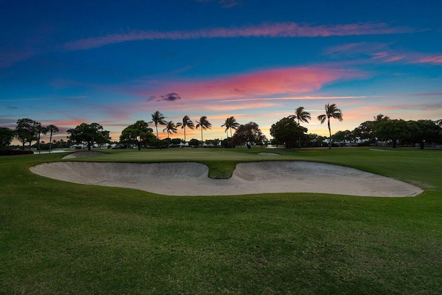 surrounding community featuring view of golf course and a yard