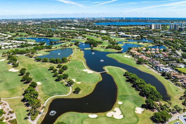 birds eye view of property with golf course view and a water view
