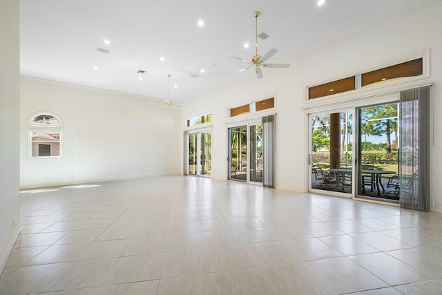 spare room featuring light tile patterned floors, ceiling fan, a high ceiling, and crown molding
