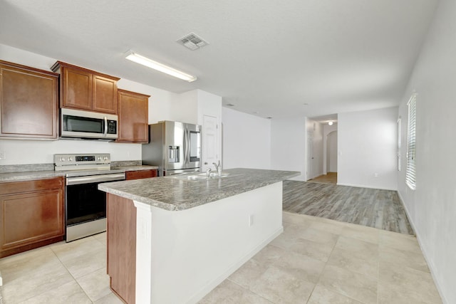 11265 SW Hadley St, Port Saint Lucie, FL 34987 - kitchen featuring a sink, light tile patterned flooring, an island with sink, stainless steel appliances, and visible vents