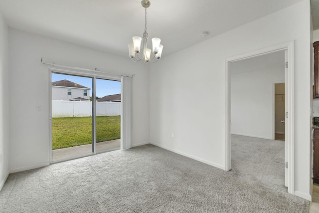11265 SW Hadley St, Port Saint Lucie, FL 34987 - empty room featuring baseboards, carpet floors, and an inviting chandelier