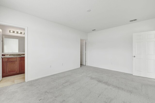 11265 SW Hadley St, Port Saint Lucie, FL 34987 - empty room featuring baseboards, visible vents, light colored carpet, and a sink