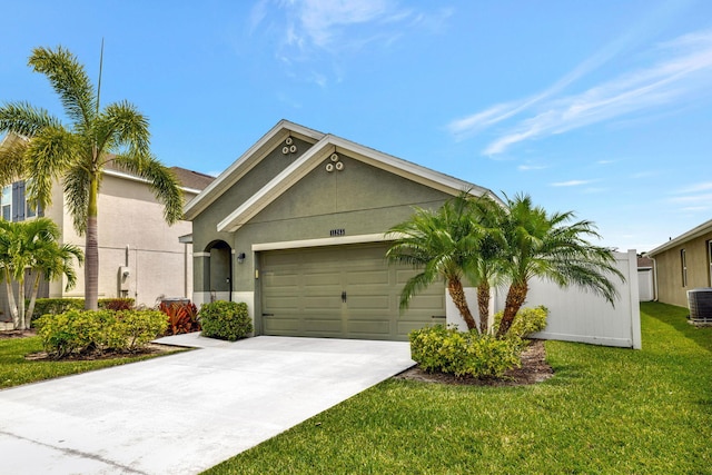 11265 SW Hadley St, Port Saint Lucie, FL 34987 - view of front of home featuring central air condition unit, a front lawn, driveway, an attached garage, and stucco siding