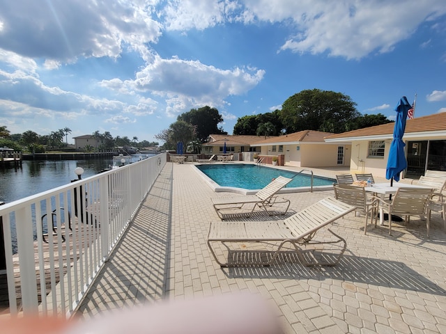 community pool featuring a water view and a patio