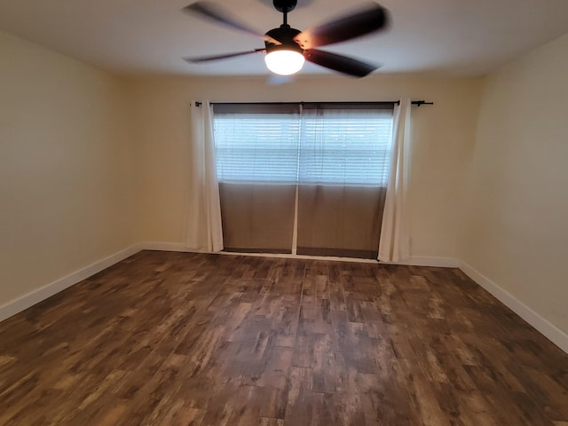 spare room featuring a ceiling fan, baseboards, and dark wood finished floors