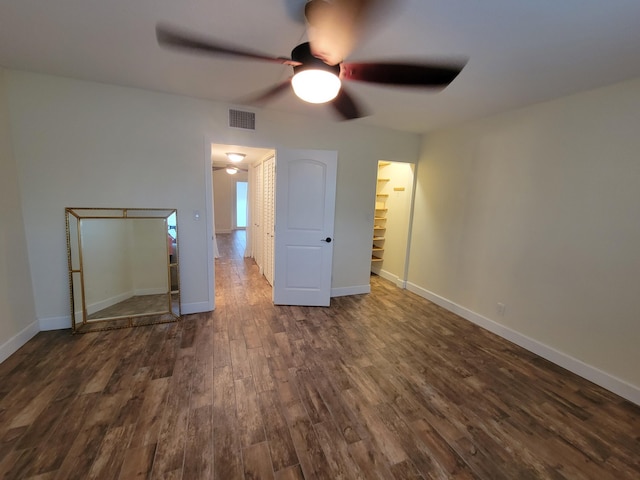 unfurnished bedroom featuring a ceiling fan, dark wood-type flooring, baseboards, and visible vents
