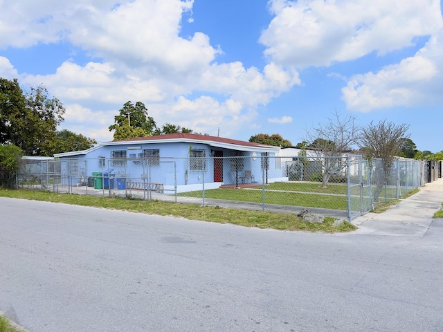 view of front of house with a front yard, a fenced front yard, a gate, and a carport