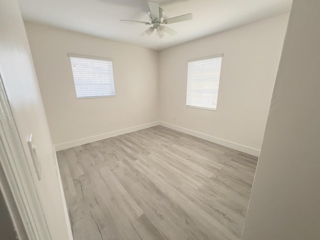 unfurnished room with plenty of natural light, baseboards, and wood finished floors