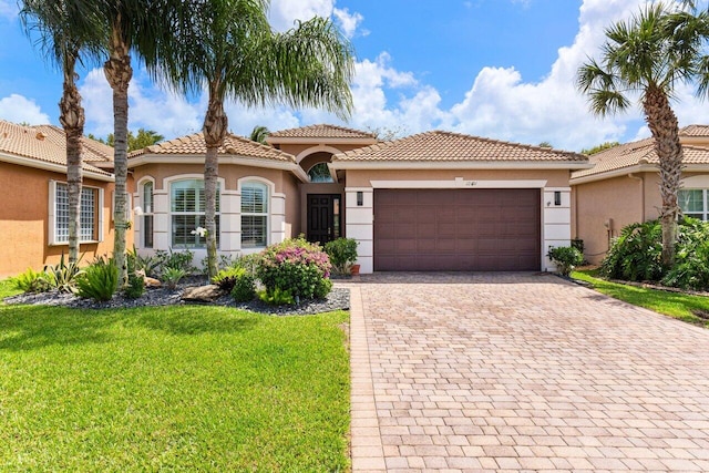12491 Laguna Valley Ter, Boynton Beach, FL 33473 - view of front facade featuring stucco siding, a tiled roof, decorative driveway, a front yard, and a garage