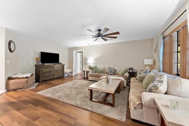 living room featuring a ceiling fan and wood finished floors
