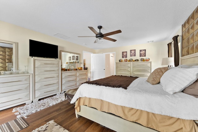 bedroom with visible vents, a ceiling fan, and dark wood-style flooring