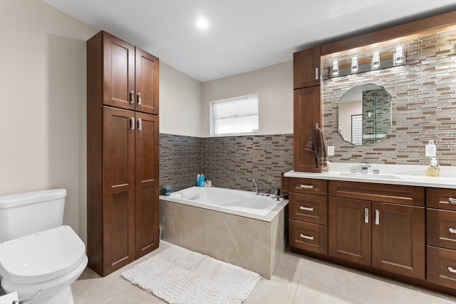 bathroom with tile patterned floors, toilet, a garden tub, and vanity
