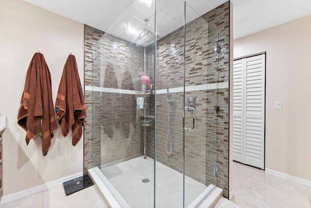 bathroom with tile patterned floors, a shower stall, and baseboards