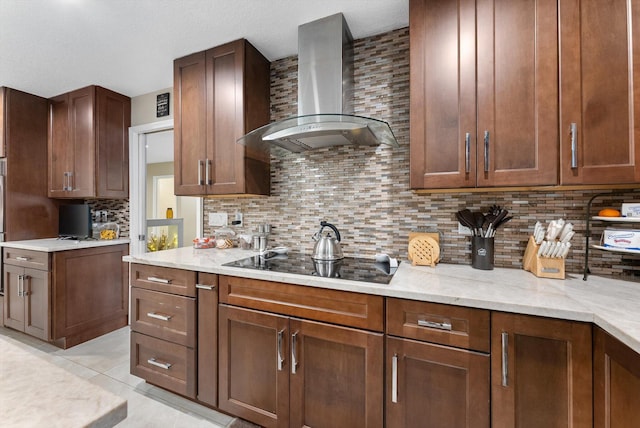 kitchen with light stone countertops, light tile patterned floors, black electric stovetop, wall chimney exhaust hood, and backsplash
