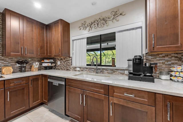kitchen with light stone counters, decorative backsplash, dishwasher, and a sink