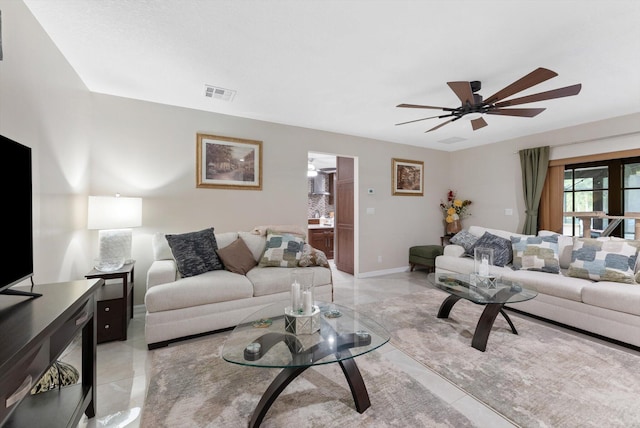 living area featuring a ceiling fan, visible vents, and baseboards