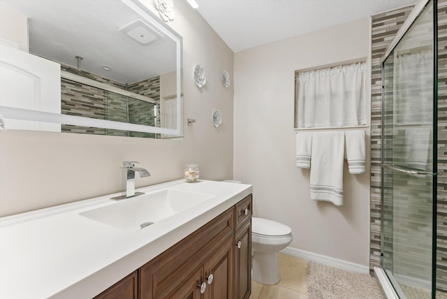 bathroom featuring a stall shower, baseboards, toilet, vanity, and tile patterned flooring