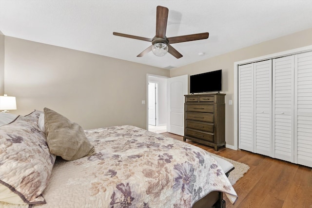 bedroom featuring a closet, ceiling fan, wood finished floors, and baseboards