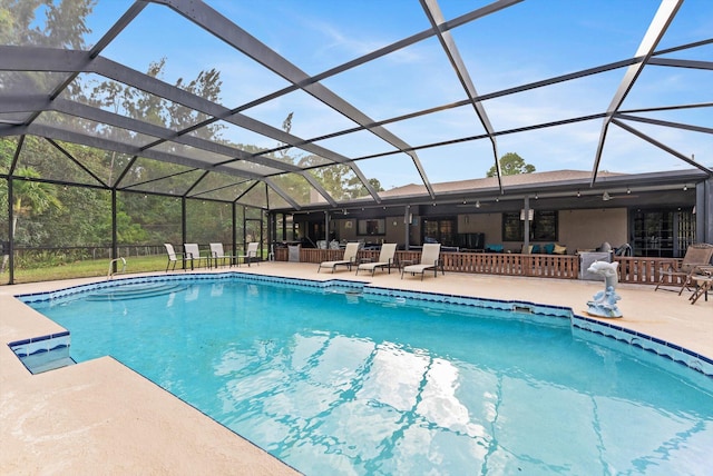 outdoor pool featuring a patio and glass enclosure