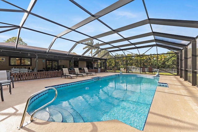 outdoor pool with glass enclosure and a patio area