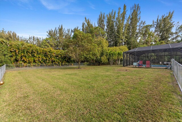 view of yard featuring a lanai, a fenced backyard, and a fenced in pool