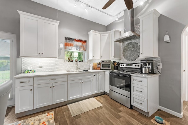 kitchen featuring a sink, white cabinetry, electric stove, and wall chimney exhaust hood