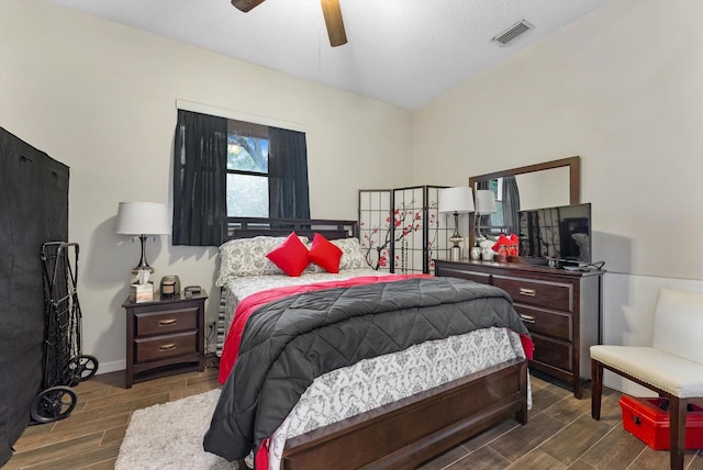 bedroom featuring a ceiling fan, visible vents, and wood finished floors