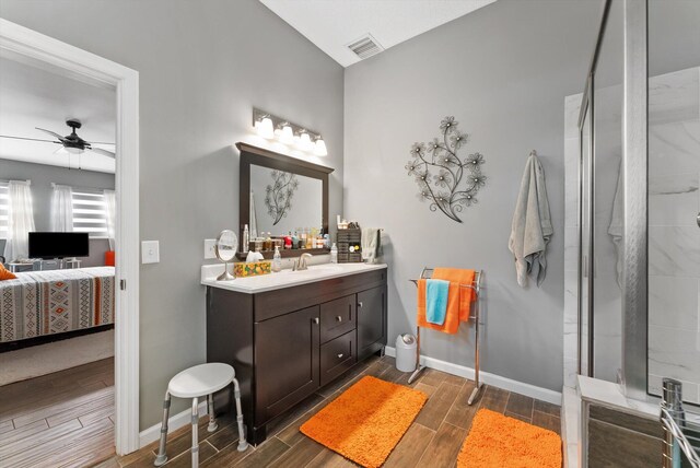 full bath with ensuite bath, baseboards, visible vents, a ceiling fan, and wood finish floors