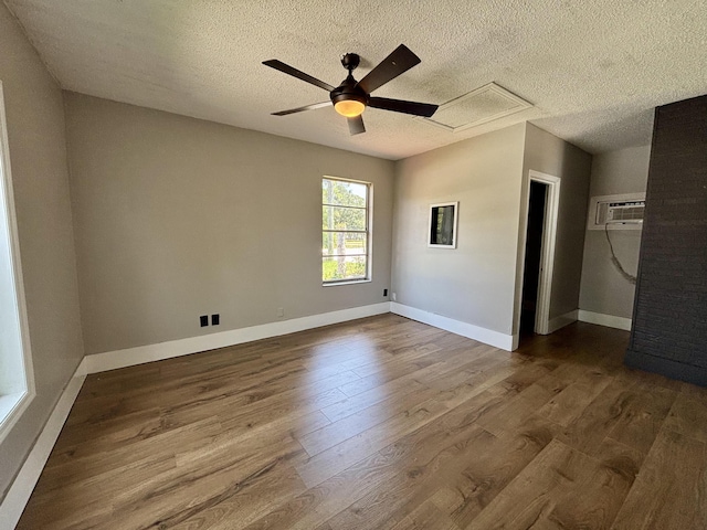 1894 NW Britt Rd, Stuart, FL 34994 - empty room with attic access, dark wood-type flooring, an AC wall unit, a ceiling fan, and a textured ceiling