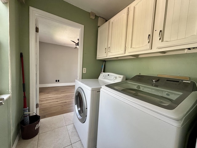 1894 NW Britt Rd, Stuart, FL 34994 - laundry area with washing machine and dryer, cabinet space, baseboards, light tile patterned floors, and a textured ceiling