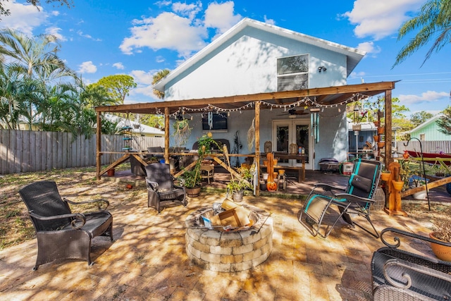 1894 NW Britt Rd, Stuart, FL 34994 - rear view of house featuring french doors, a fire pit, a fenced backyard, and a patio