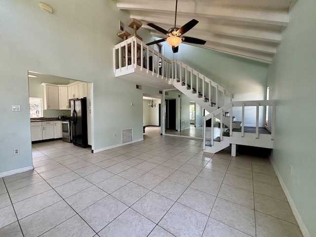1894 NW Britt Rd, Stuart, FL 34994 - unfurnished living room with high vaulted ceiling, light tile patterned floors, stairway, a ceiling fan, and baseboards