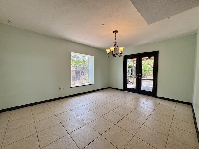 1894 NW Britt Rd, Stuart, FL 34994 - empty room with light tile patterned floors, a chandelier, french doors, baseboards, and a textured ceiling
