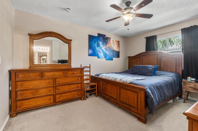 bedroom featuring light colored carpet, a ceiling fan, baseboards, and a textured ceiling