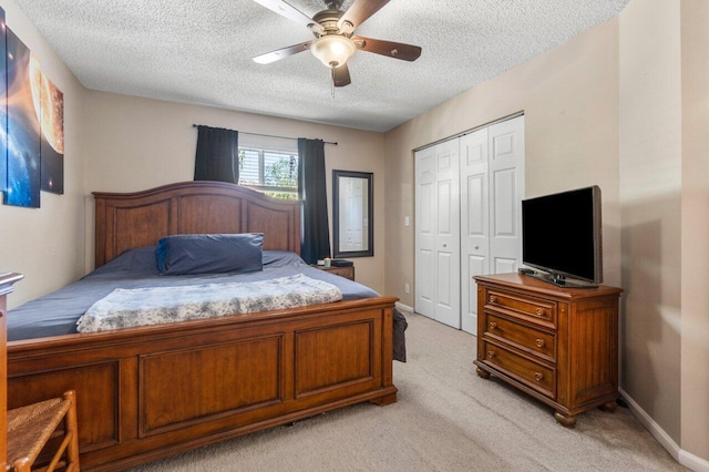 bedroom with light carpet, baseboards, a closet, and a textured ceiling