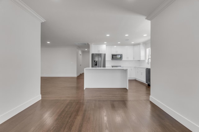 4015 Washington Rd, West Palm Beach, FL 33405 - kitchen featuring crown molding, white cabinetry, a kitchen island, stainless steel appliances, and baseboards