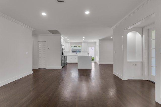 4015 Washington Rd, West Palm Beach, FL 33405 - unfurnished living room featuring arched walkways, dark wood-style floors, baseboards, and crown molding