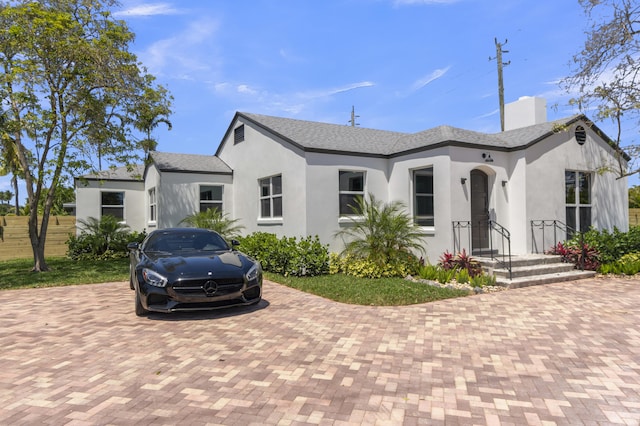 4015 Washington Rd, West Palm Beach, FL 33405 - view of front facade featuring decorative driveway, stucco siding, and a chimney