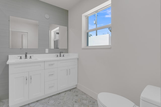 4015 Washington Rd, West Palm Beach, FL 33405 - bathroom with a sink, toilet, double vanity, and baseboards