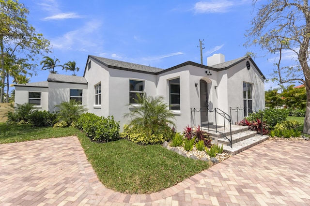 4015 Washington Rd, West Palm Beach, FL 33405 - view of front of home with stucco siding and a chimney